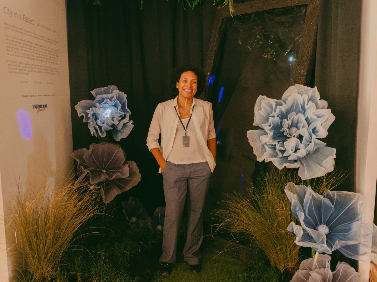 Laila Jhané standing among the oversized blue paper blooms inside the installation.